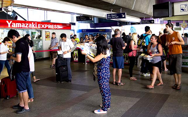 Tourist looking for information on a map, in a Bangkok Skytrain station.